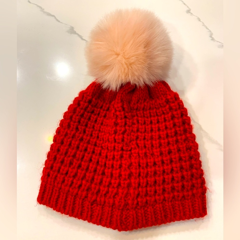 Red hat with pink pom on top